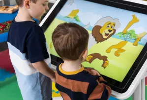 Interactive Touchscreen Table_Early Years - two nursery aged children playing with a jigsaw of a lion