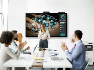 People clapping in a meeting room with an on-screen presentation and printer in the background